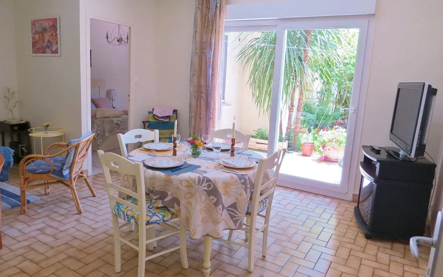 The apartment's living room: laid table, seating area and patio door opening onto the garden